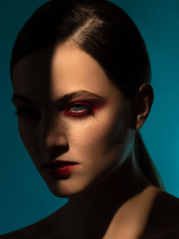 Ritratto beauty di modella in studio fotografico su sfondo azzurro