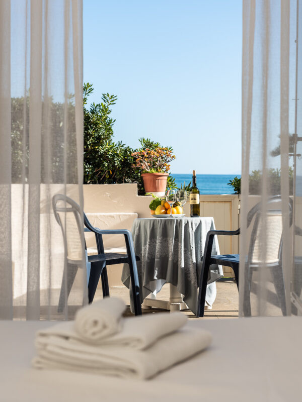 Vista del letto con asciugamani e balcone esterno dell'hotel Maga Circe sul Circeo