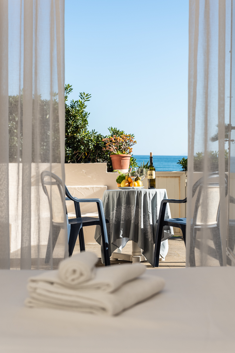 Vista del letto con asciugamani e balcone esterno dell'hotel Maga Circe sul Circeo