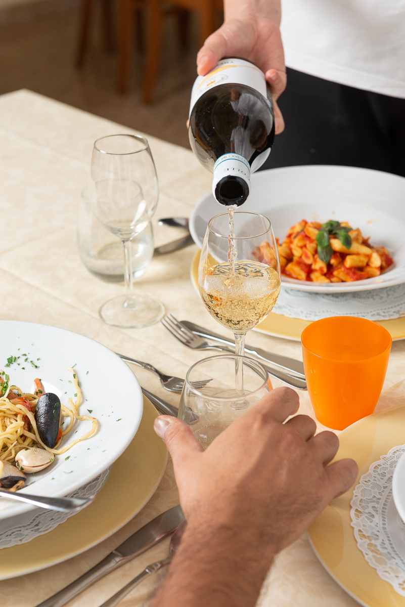 Vino bianco viene versato in un calice durante un pranzo all'hotel JeanPierre di Tortoreto